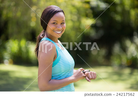 Happy woman posing and touching her watch Happy woman posing and touching her watch 24217562