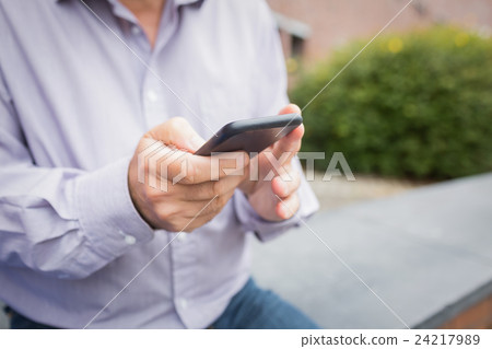 Mid section of a man using mobile phone 24217989