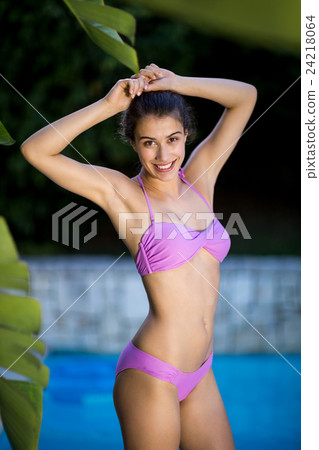 Beautiful woman standing at poolside Beautiful woman standing at poolside 24218064