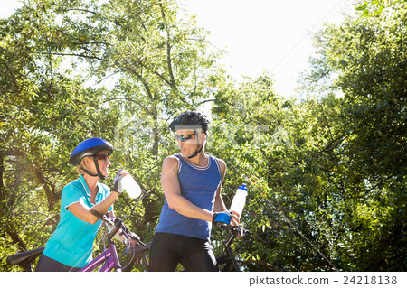 Senior couple standing with their bikes Senior couple standing with their bikes 24218138