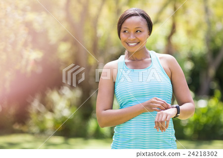 Happy woman posing and touching her watch Happy woman posing and touching her watch 24218302