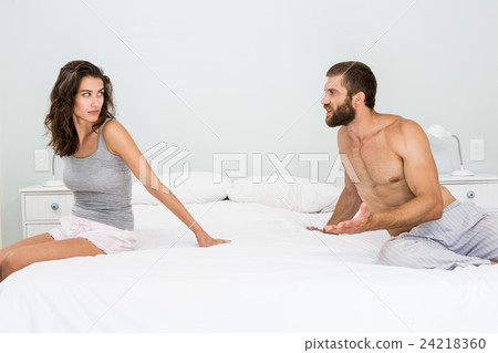 Man arguing with woman on bed Man arguing with woman on bed 24218360