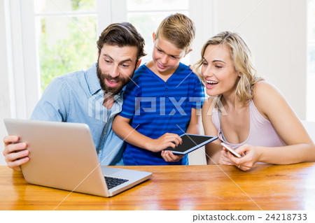 Parents and son using a laptop, tablet and phone Parents and son using a laptop, tablet and phone 24218733