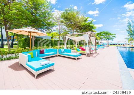 Umbrella and chair around swimming pool Umbrella and chair around swimming pool 24239459