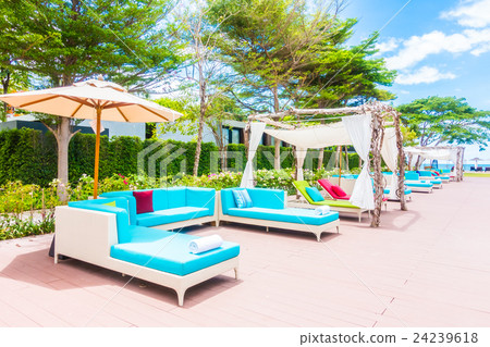 Umbrella and chair around swimming pool Umbrella and chair around swimming pool 24239618