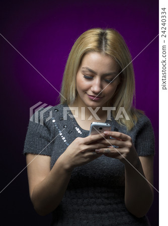 blonde haired model holding smartphone on black blonde haired model holding smartphone on black 24240334