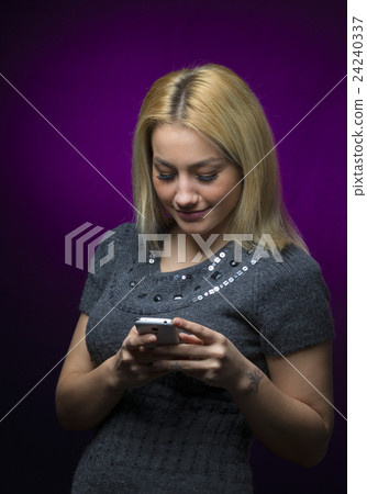 blonde haired model holding smartphone on black blonde haired model holding smartphone on black 24240337