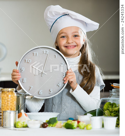 Portrait of sweet little girl with veggies and clock 24245334