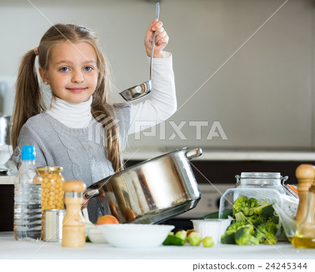 Smiling little girl learning to cook in kitchen Smiling little girl learning to cook in kitchen 24245344