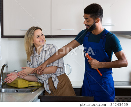 plumber and housewife in kitchen plumber and housewife in kitchen 24245469