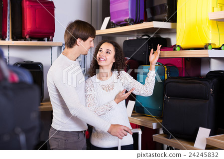 customers looking at roll-aboard bags in store customers looking at roll-aboard bags in store 24245832