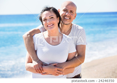 Couple gladly hugging each other and enjoying the beach Couple gladly hugging each other and enjoying the beach 24246350