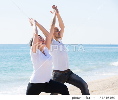 man and woman exercising together on the beach man and woman exercising together on the beach 24246360
