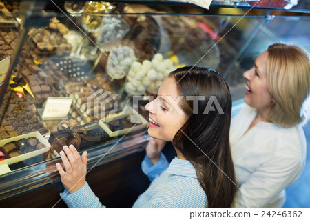 Female friends selecting fine chocolates and confectionery Female friends selecting fine chocolates and confectionery 24246362