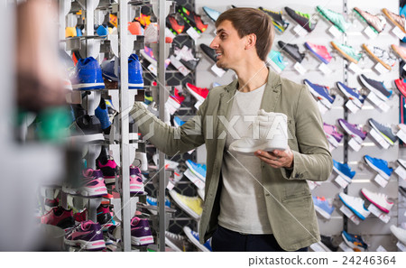 Young man picking a sporty shoes . 24246364