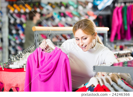 Girl picking a cardigan in the shop. 24246366