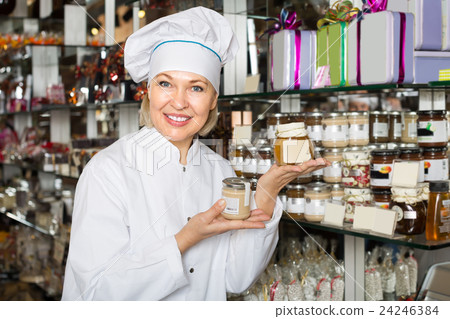 Saleswoman with sweets in jars. 24246384