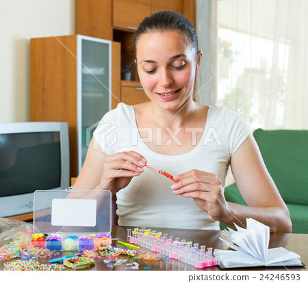 Girl makes decorative bracelet 24246593