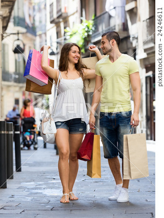 Smiling young pair with shopping pack at city 24246611