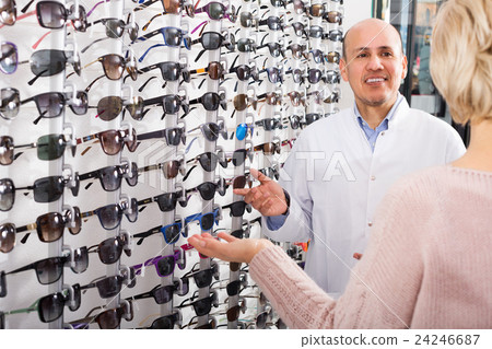Male optician offering glasses frames Male optician offering glasses frames 24246687
