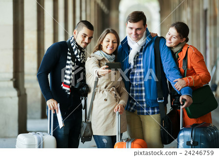Group of friends shooting mutual portrait on cell phone Group of friends shooting mutual portrait on cell phone 24246759