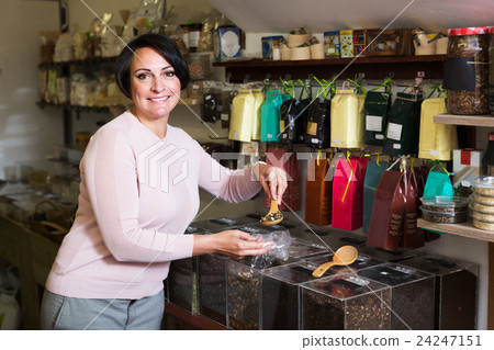 Woman selecting tea in store Woman selecting tea in store 24247151