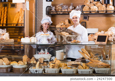 Smiling man and girl selling pastry and loaves Smiling man and girl selling pastry and loaves 24247300