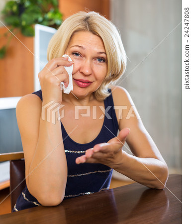 Sad female sitting on table Sad female sitting on table 24247808
