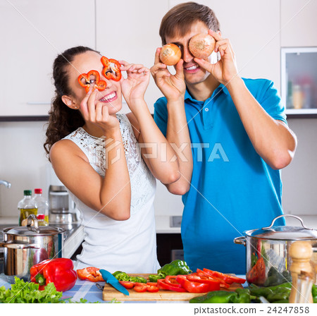 Young family couple cooking vegetables Young family couple cooking vegetables 24247858