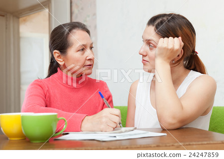 Two serious women fills in documents Two serious women fills in documents 24247859