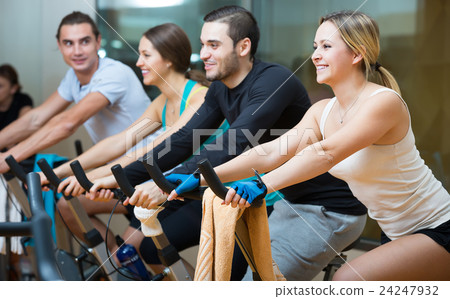 Young adults on exercise bikes in gym Young adults on exercise bikes in gym 24247932