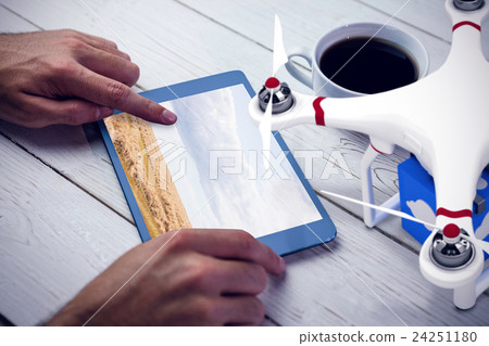 Composite image of a drone bringing a blue cube Composite image of a drone bringing a blue cube 24251180