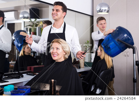 Professional stylist cutting hair of elderly blonde 24264584
