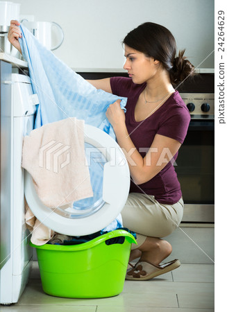 Unhappy girl near washing machine. 24264629
