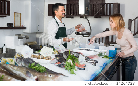 Customer buying cooled fish. 24264728