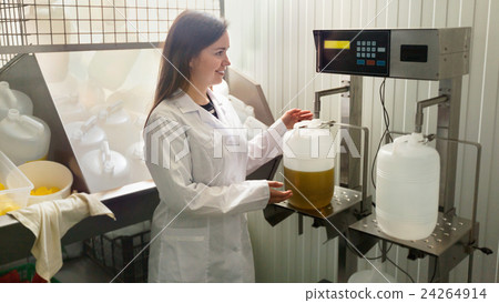 Portrait of female engineer filling containers with olive oil 24264914
