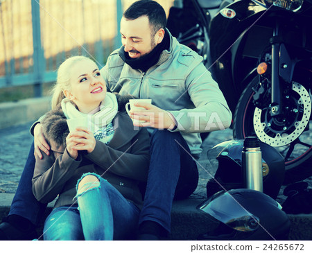 Couple drinking coffee near motorcycle Couple drinking coffee near motorcycle 24265672