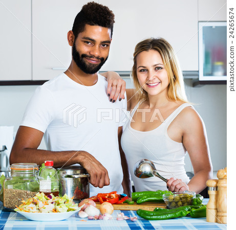 Interracial couple cooking vegetables 24265674