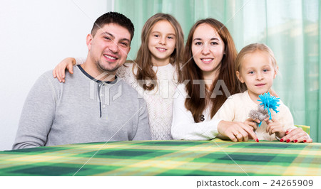 Ordinary happy family of four at table 24265909