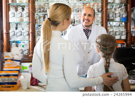 Smiling male pharmacist helping customers Smiling male pharmacist helping customers 24265994