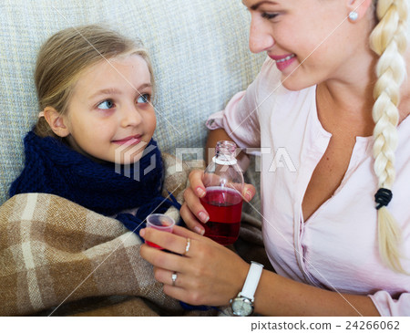 Stressed woman giving liquid medicine to little girl with grippe Stressed woman giving liquid medicine to little girl with grippe 24266062