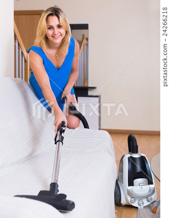 housewife in casual hoovering at home 24266218