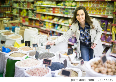 Cheerful woman purchasing lentil in shop Cheerful woman purchasing lentil in shop 24266239