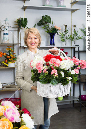 Cheerful mature blond woman selecting flowers 24266868