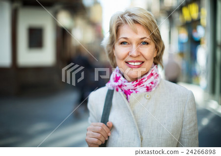 Portrait of smiling mature blond woman in town Portrait of smiling mature blond woman in town 24266898