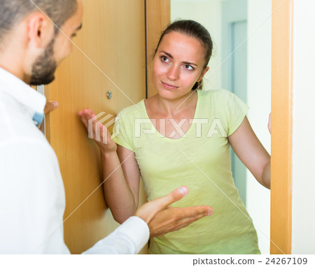 pair quarrels standing at the doorway 24267109