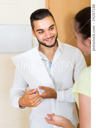 man and woman standing with papers at the door man and woman standing with papers at the door 24267286