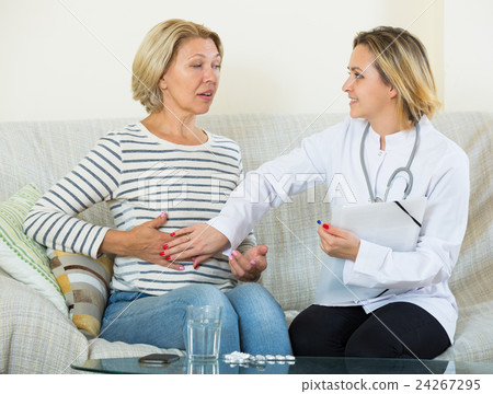 Young therapeutist and senior female with pain in belly Young therapeutist and senior female with pain in belly 24267295
