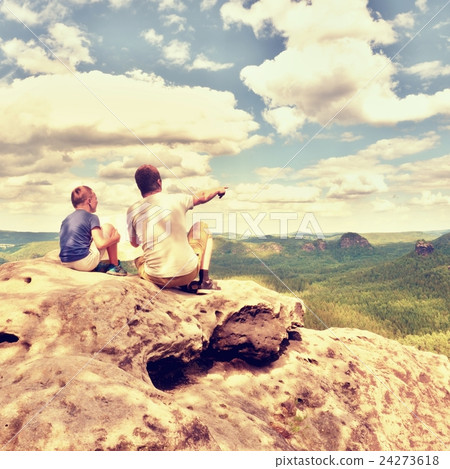 Father and son on mountain watching into land Father and son on mountain watching into land 24273618