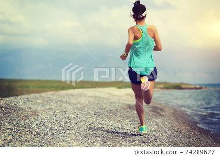 young woman trail runner running on seaside 24289677